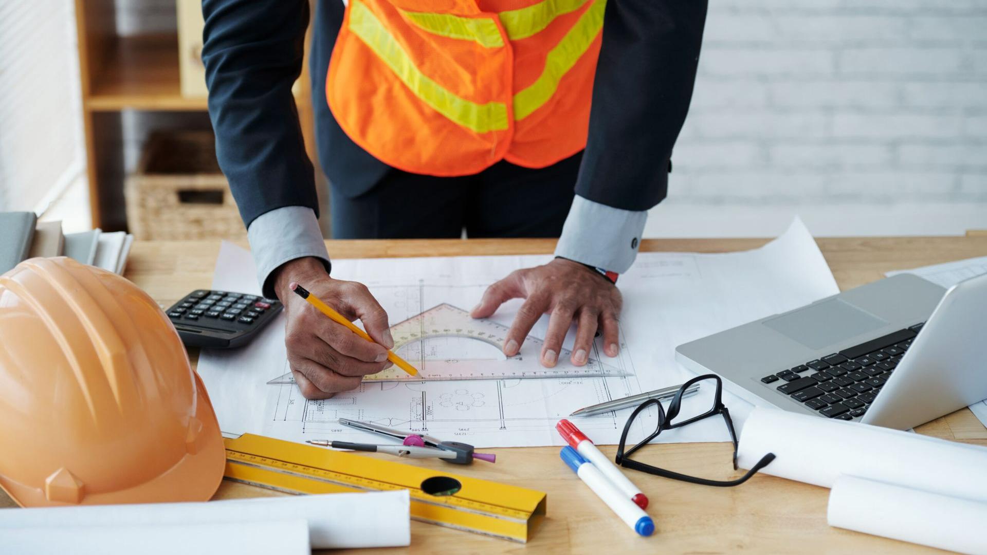 Un métreur assistant du bâtiment prépare des plans de construction